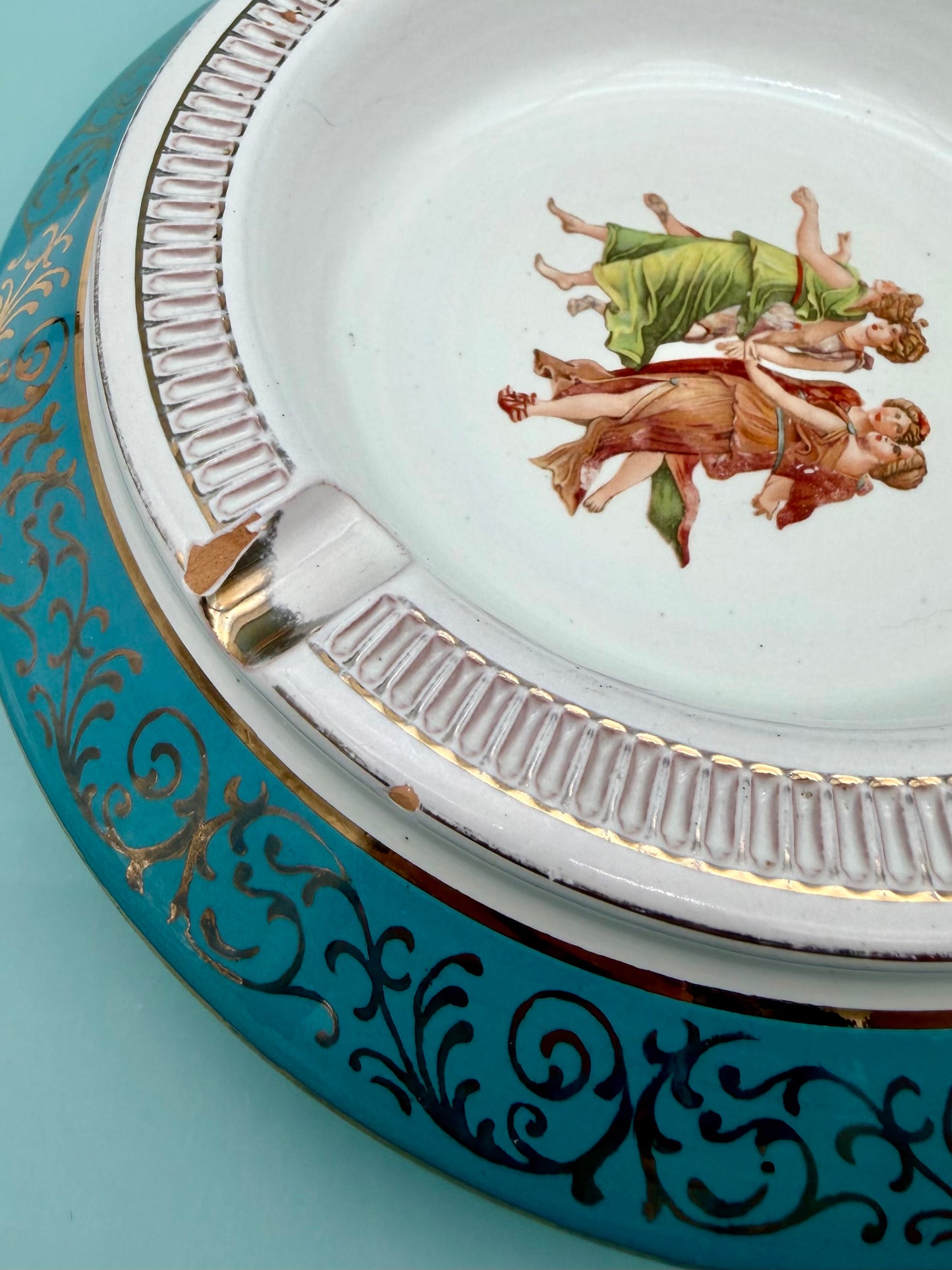 Close-up of the gold scrollwork trim and dancing figures medallion from a different angle, turquoise porcelain