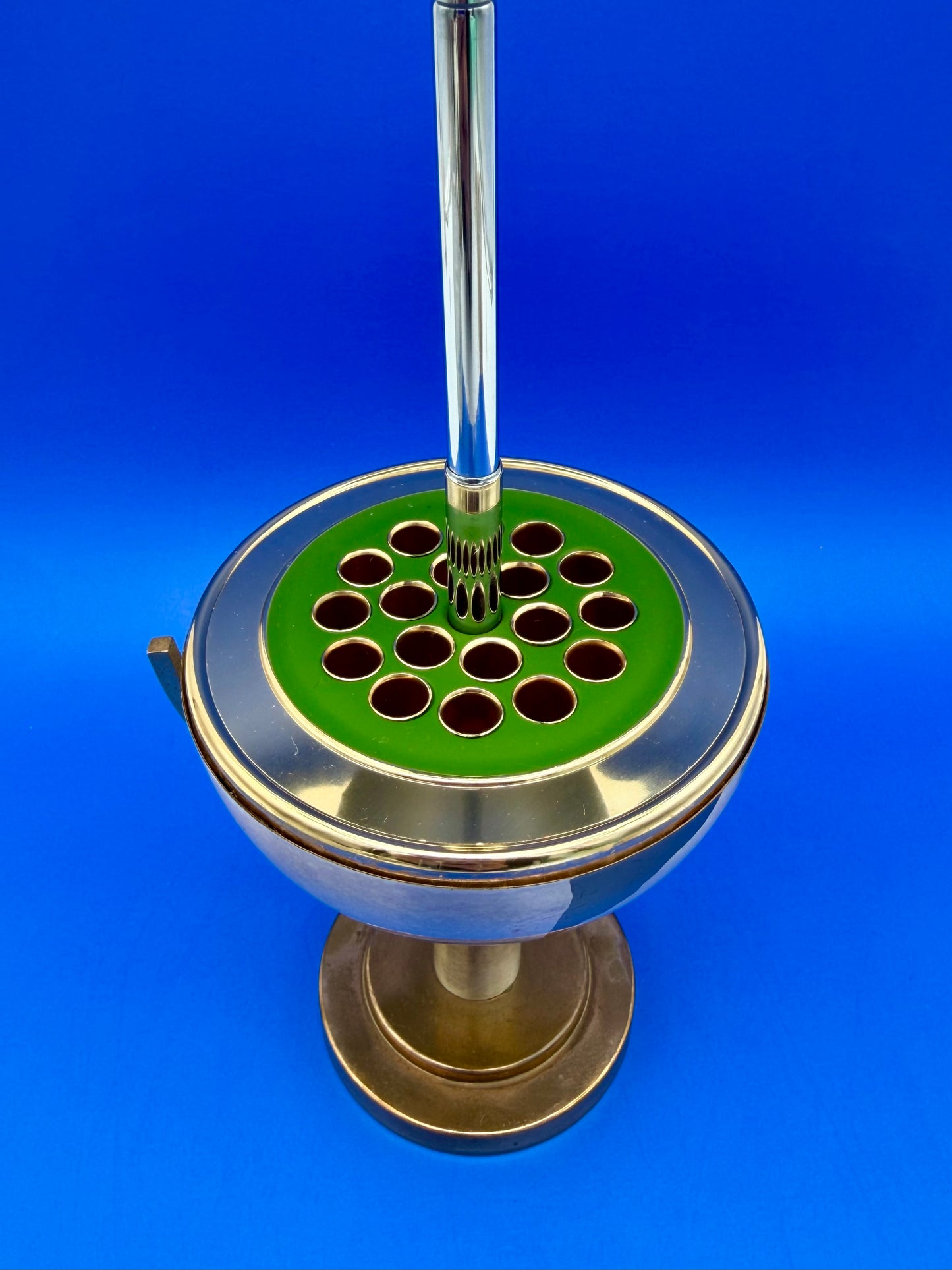Close-up of the open brass globe cigarette holder showing the pop-up cigarette holder ring