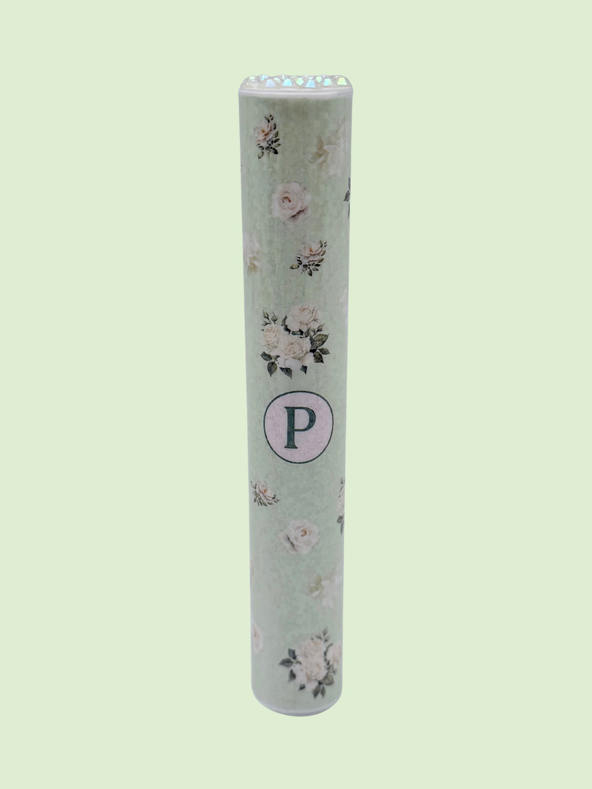 Single mint green floral doob tube with rhinestone lid standing upright on a green background