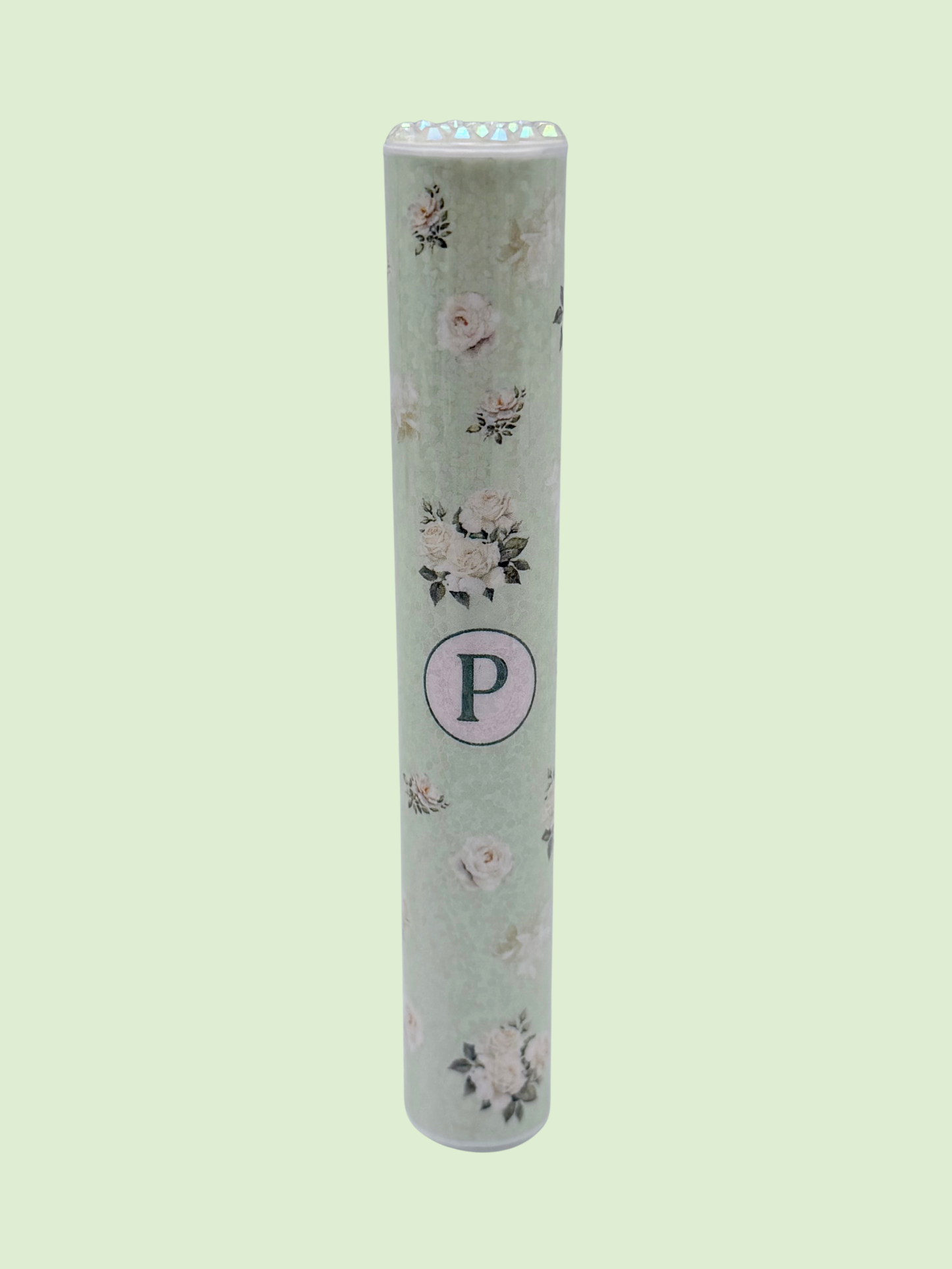 Single mint green floral doob tube with rhinestone lid standing upright on a green background