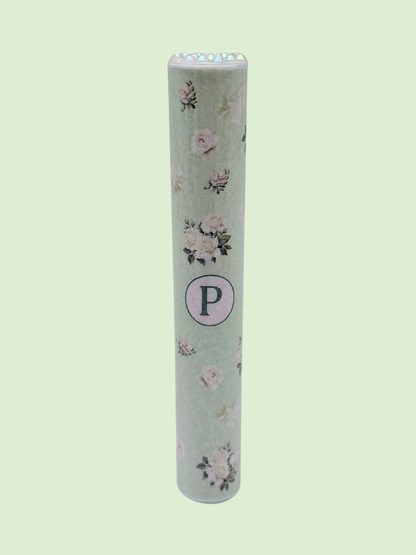 Single mint green floral doob tube with rhinestone lid standing upright on a green background