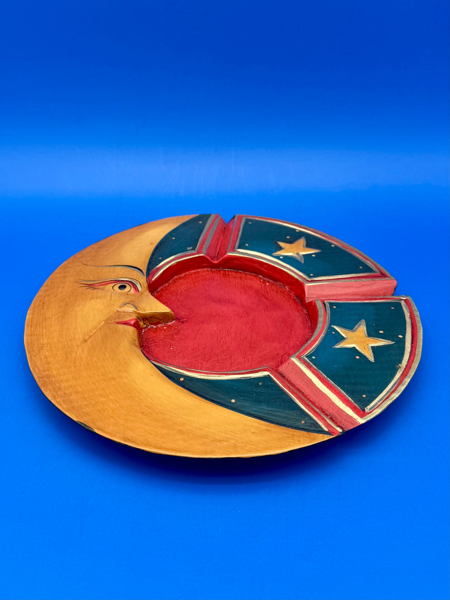 Crescent moon wooden ashtray shown from another angle highlighting the star-decorated blue panels, blue background