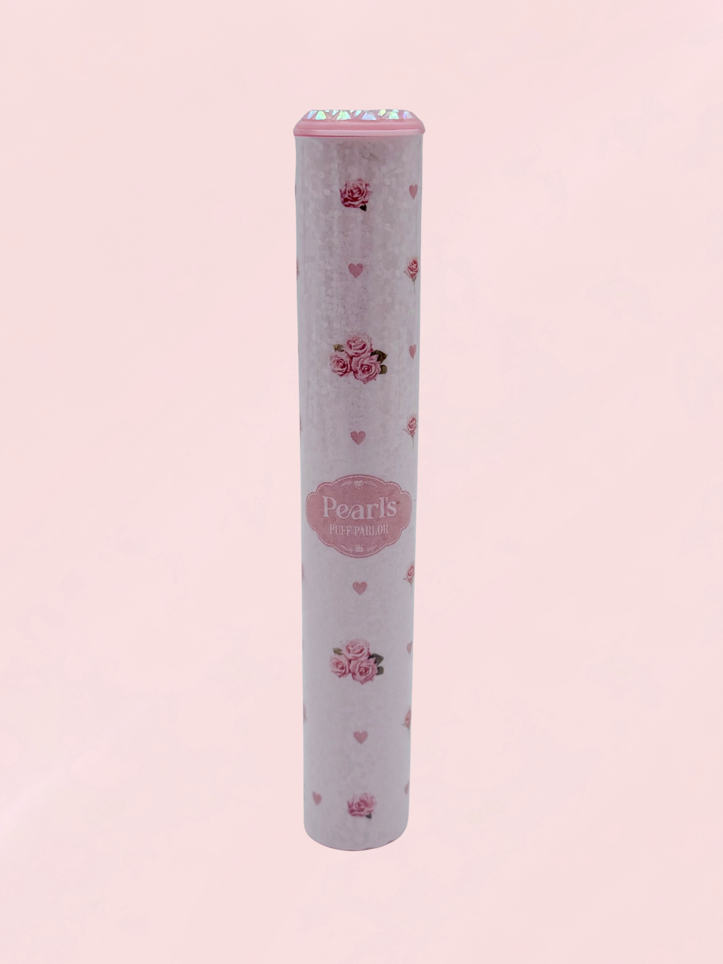 Single pink rosebud and heart print doob tube with rhinestone lid standing upright on a pink background