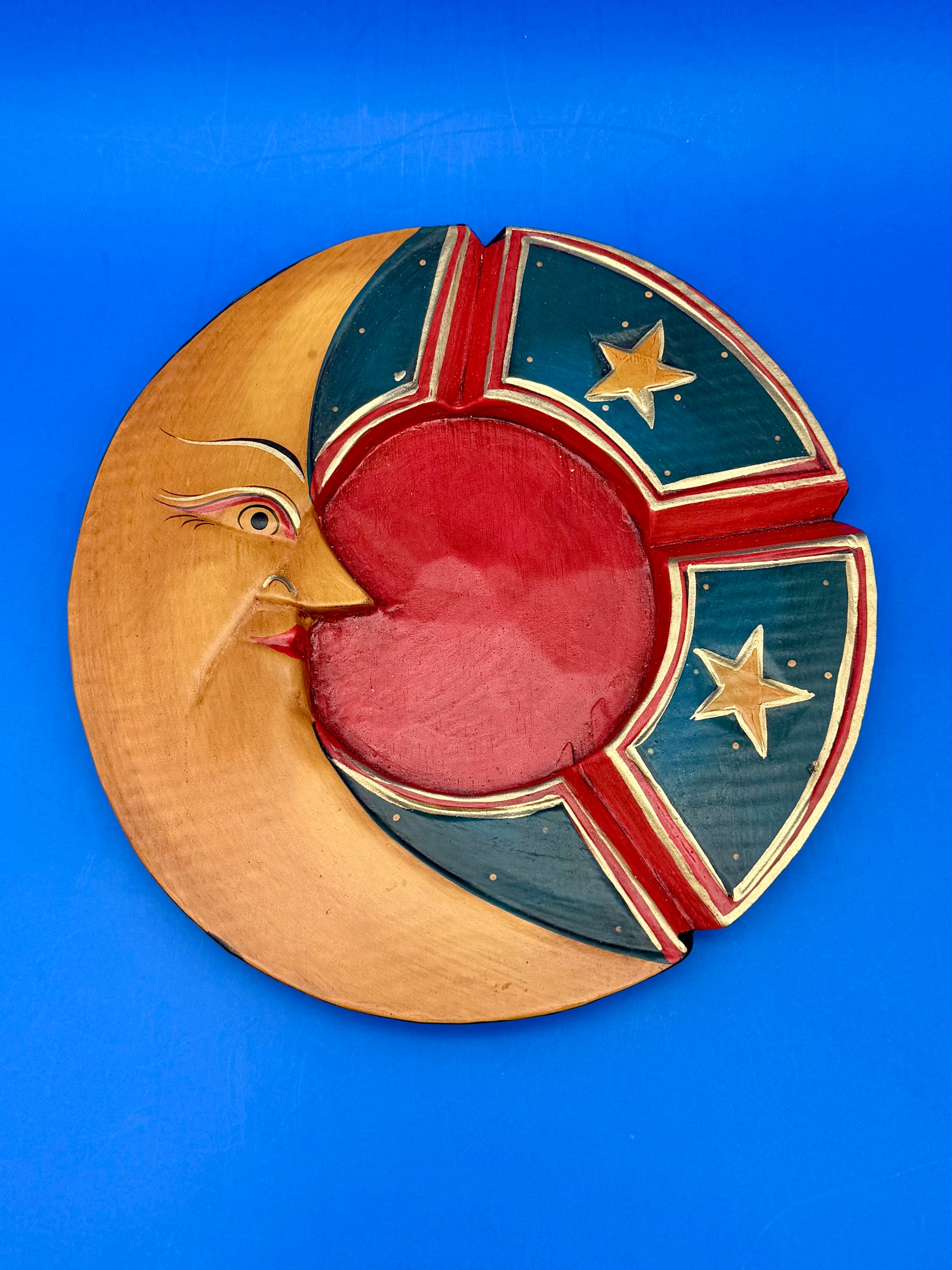 Same crescent moon wooden ashtray shown from a different angle, blue background