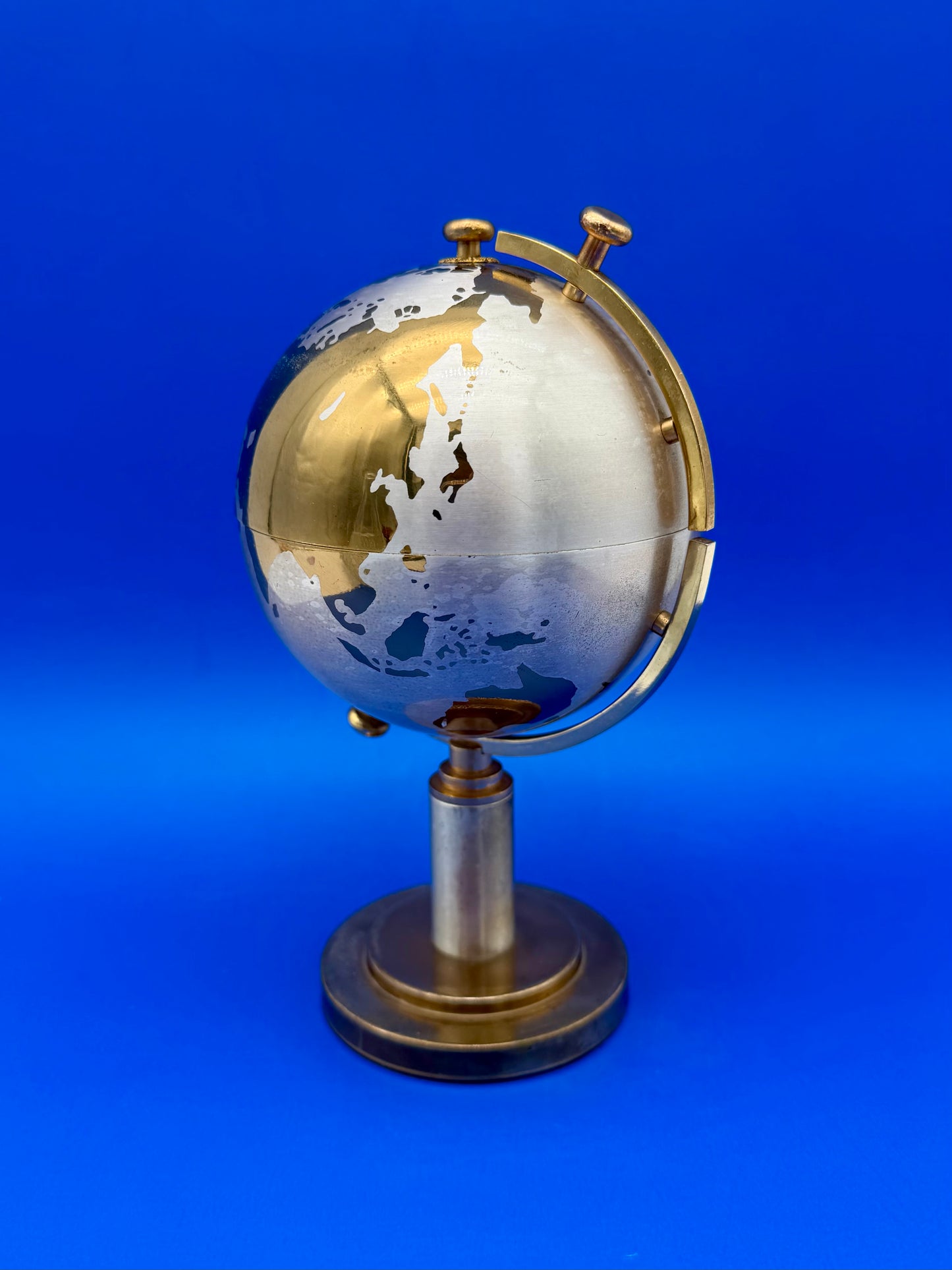 Brass globe cigarette holder closed, shown from a different angle on its pedestal stand