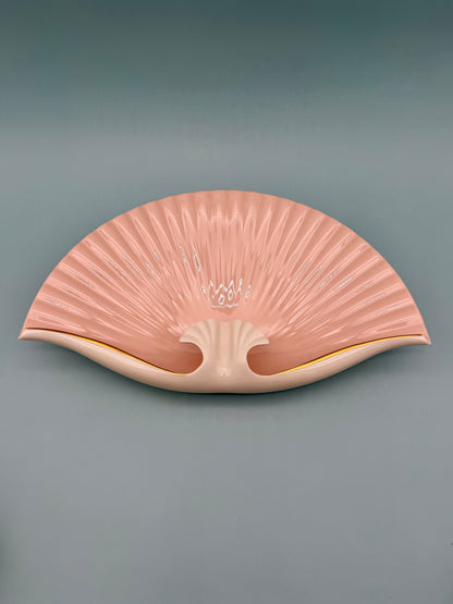 Seashell-shaped porcelain ashtray with delicate pink floral detail at the center, gray background