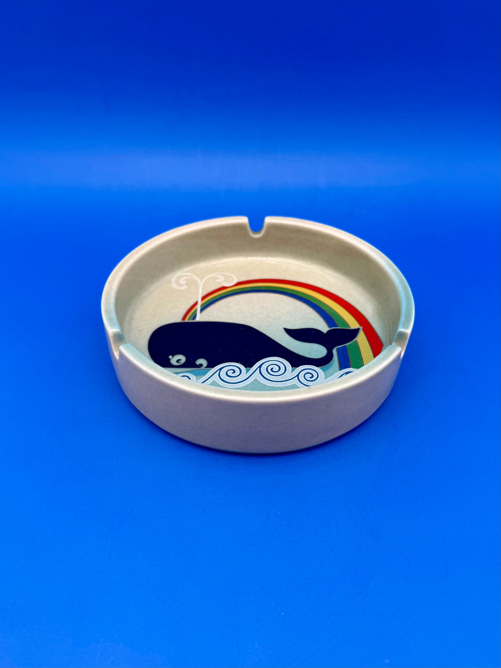 Same whale and rainbow ashtray shown from a different angle, blue background