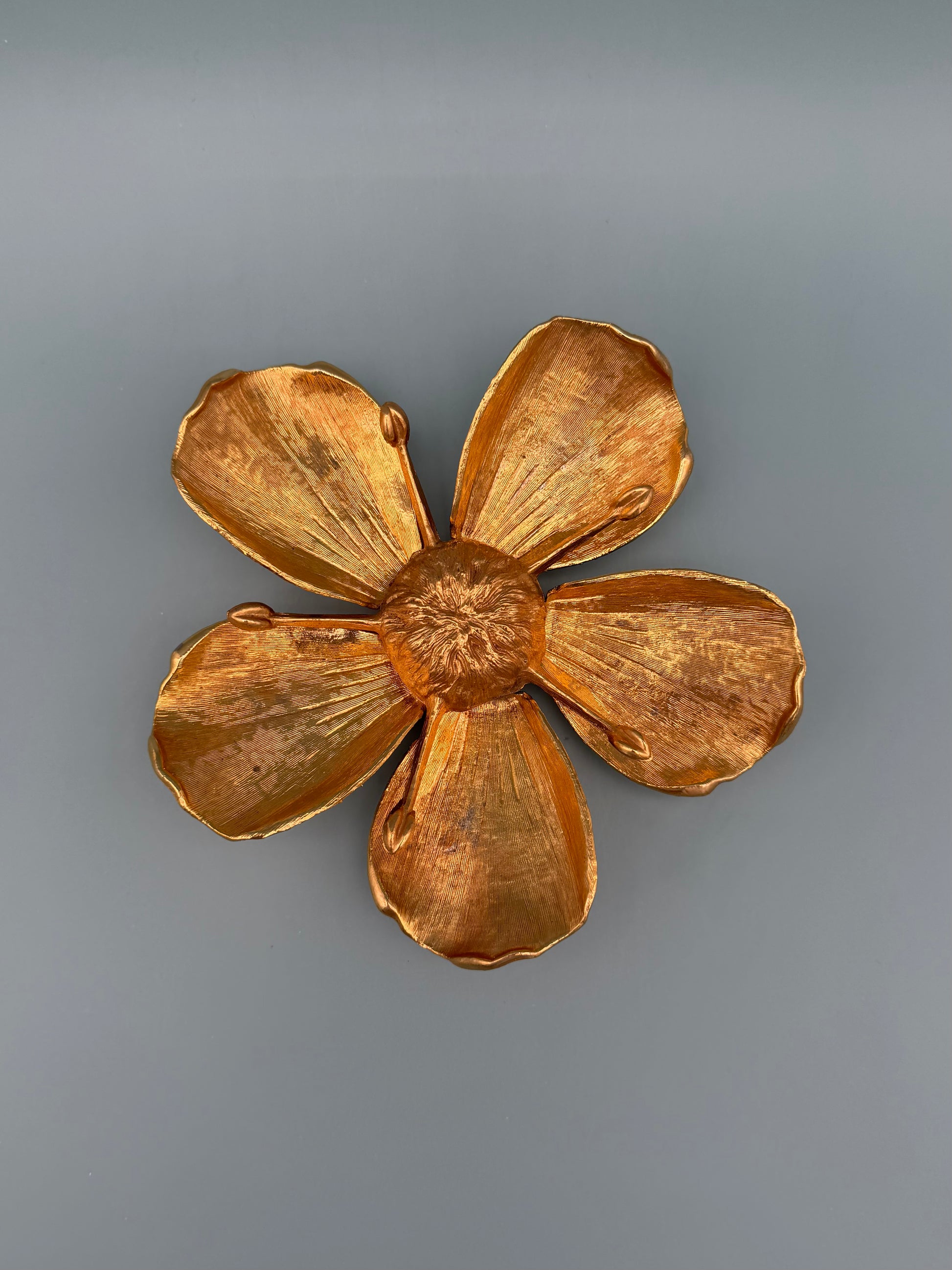 Same gold marigold flower-shaped dish shown alone without the teardrop piece, gray-blue background.