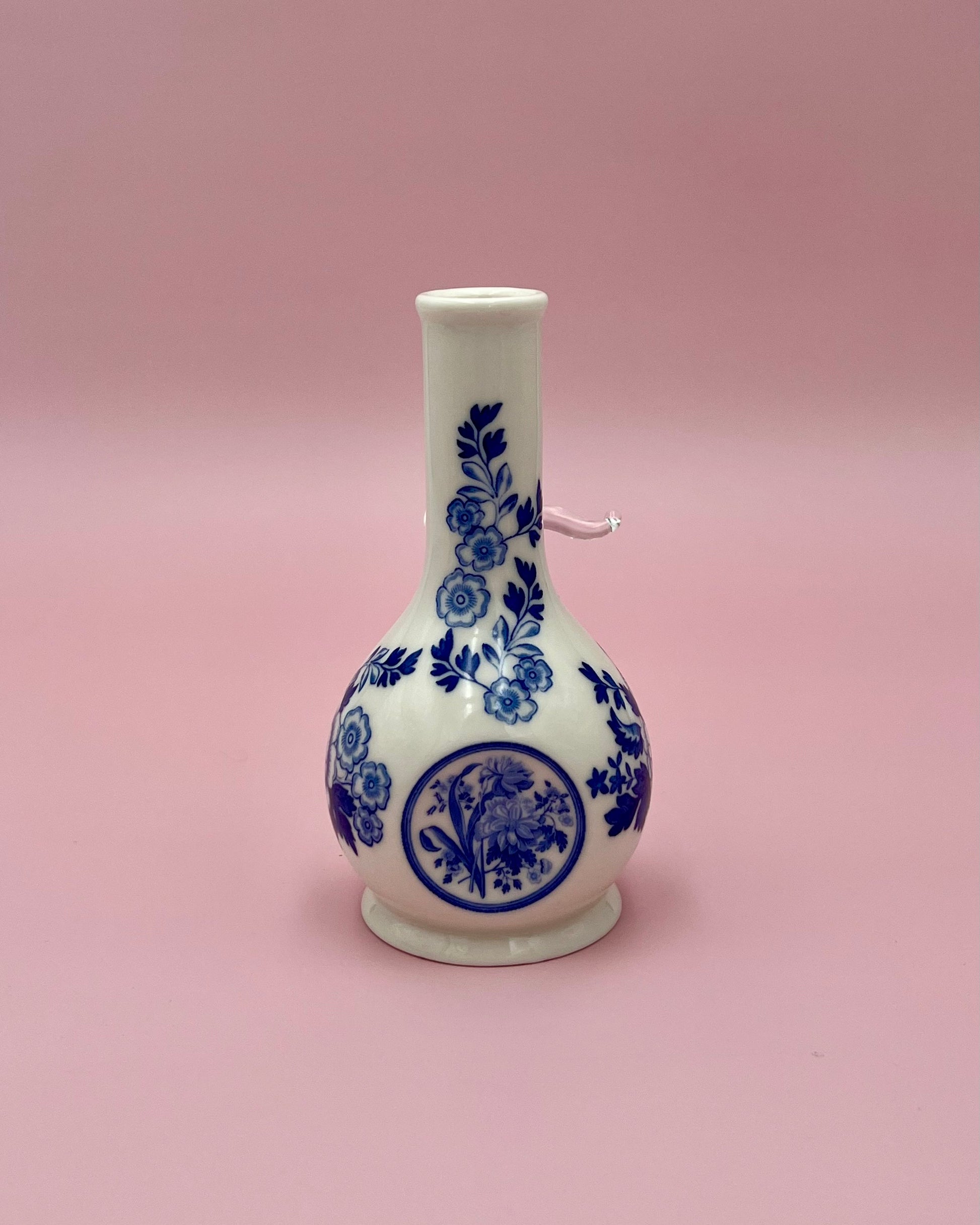 Close, straight-on view of the Betty water pipe highlighting the blue floral toile pattern and center medallion, pink background.