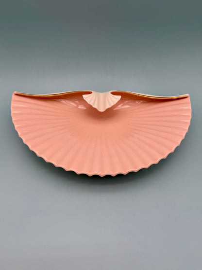 Seashell-shaped porcelain ashtray shown from the front with ridges fanned open, gray background