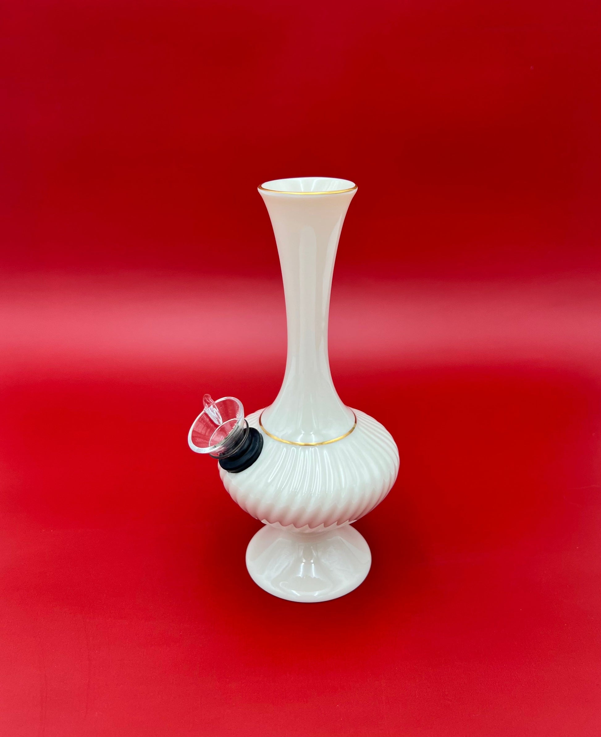 Side view of the Carol water pipe showing the ribbed texture and glass bowl and mouthpiece fittings, deep red background.