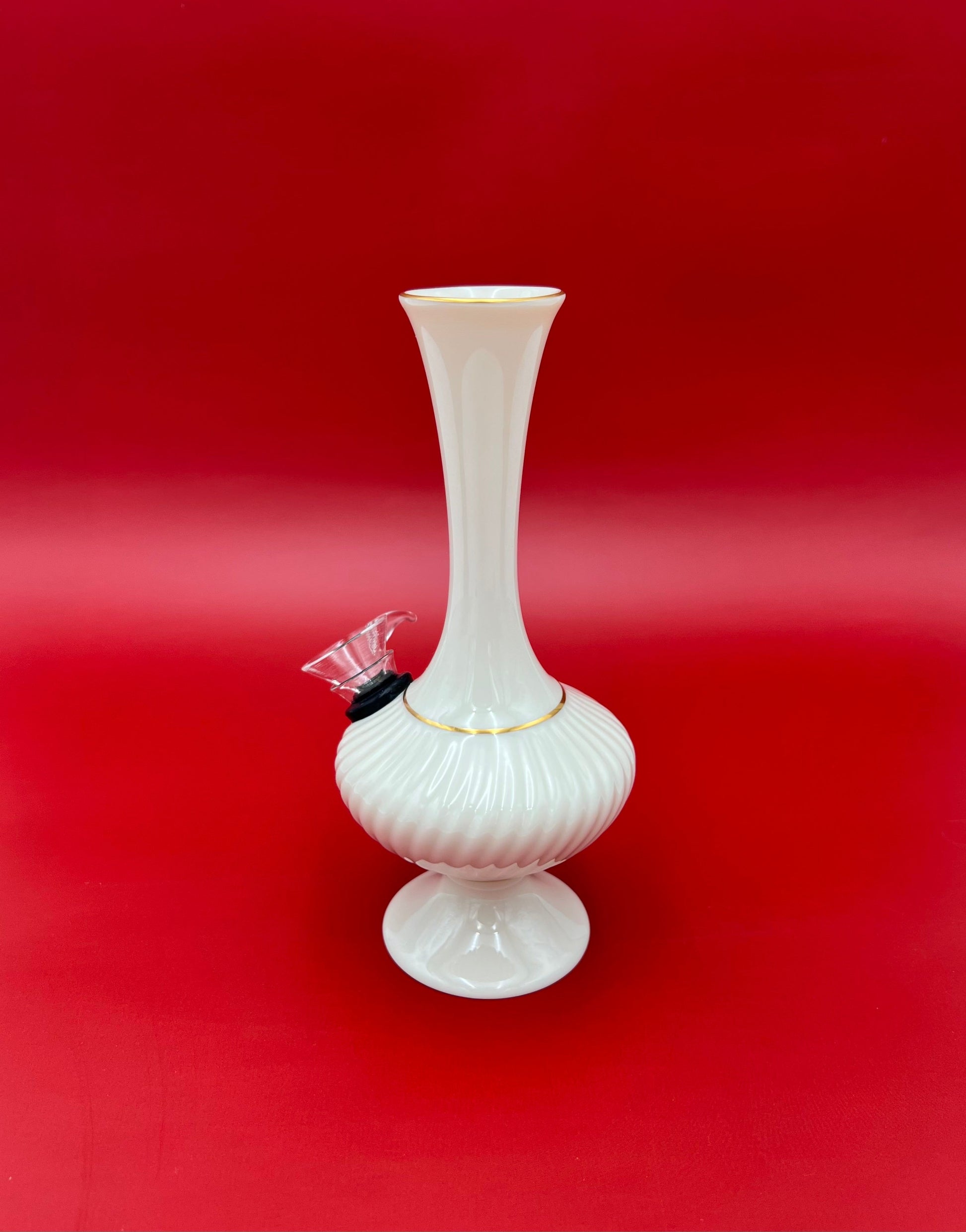 Another side angle of the Carol water pipe showing the glass fittings against the fluted body, deep red background.