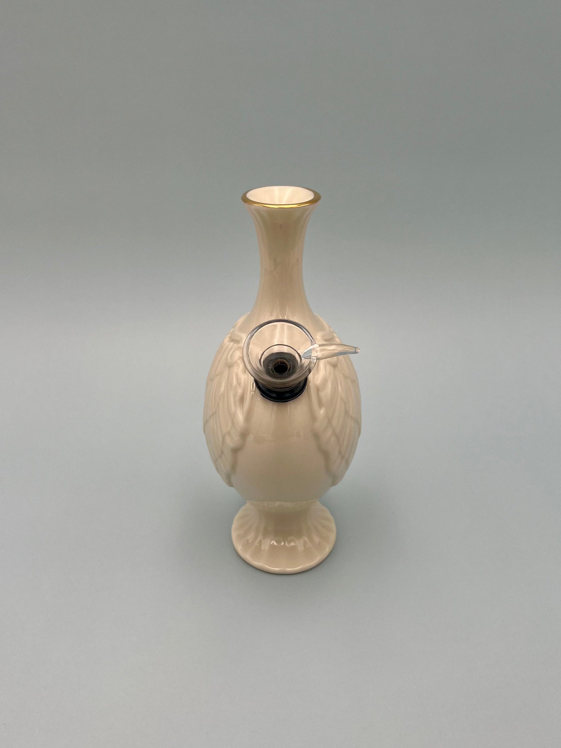 Side view of the same pale blush ribbed porcelain bud vase water pipe, showing the glass bowl piece attached at the base, gray background.
