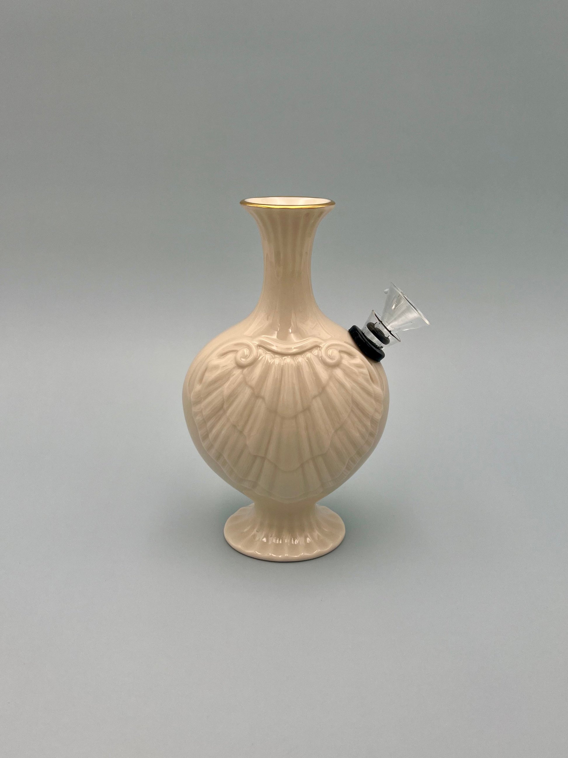 Front view of a pale blush ribbed porcelain bud vase water pipe with a fluted trumpet top, glass bowl piece on the side, gray background.