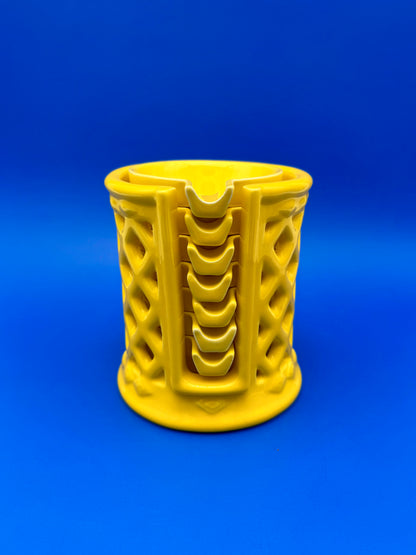 Yellow ceramic lattice-cut ashtray holder alone with vertical ribbed design, blue background