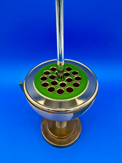 Close-up of the open brass globe cigarette holder showing the pop-up cigarette holder ring