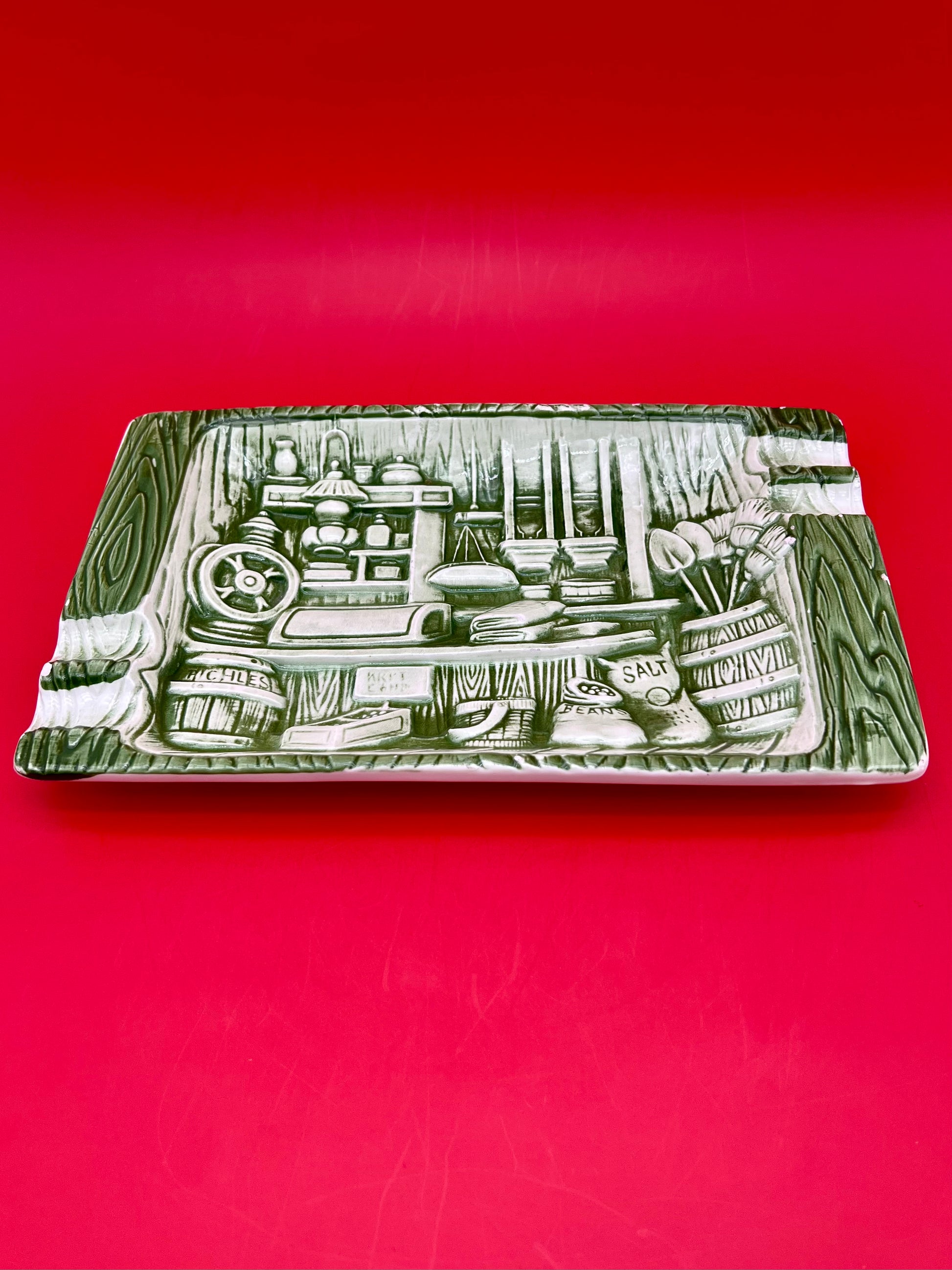 Same sage green rectangular tray etched with the vintage kitchen pantry scene, shown without the cigarette pick, closer view, red background.