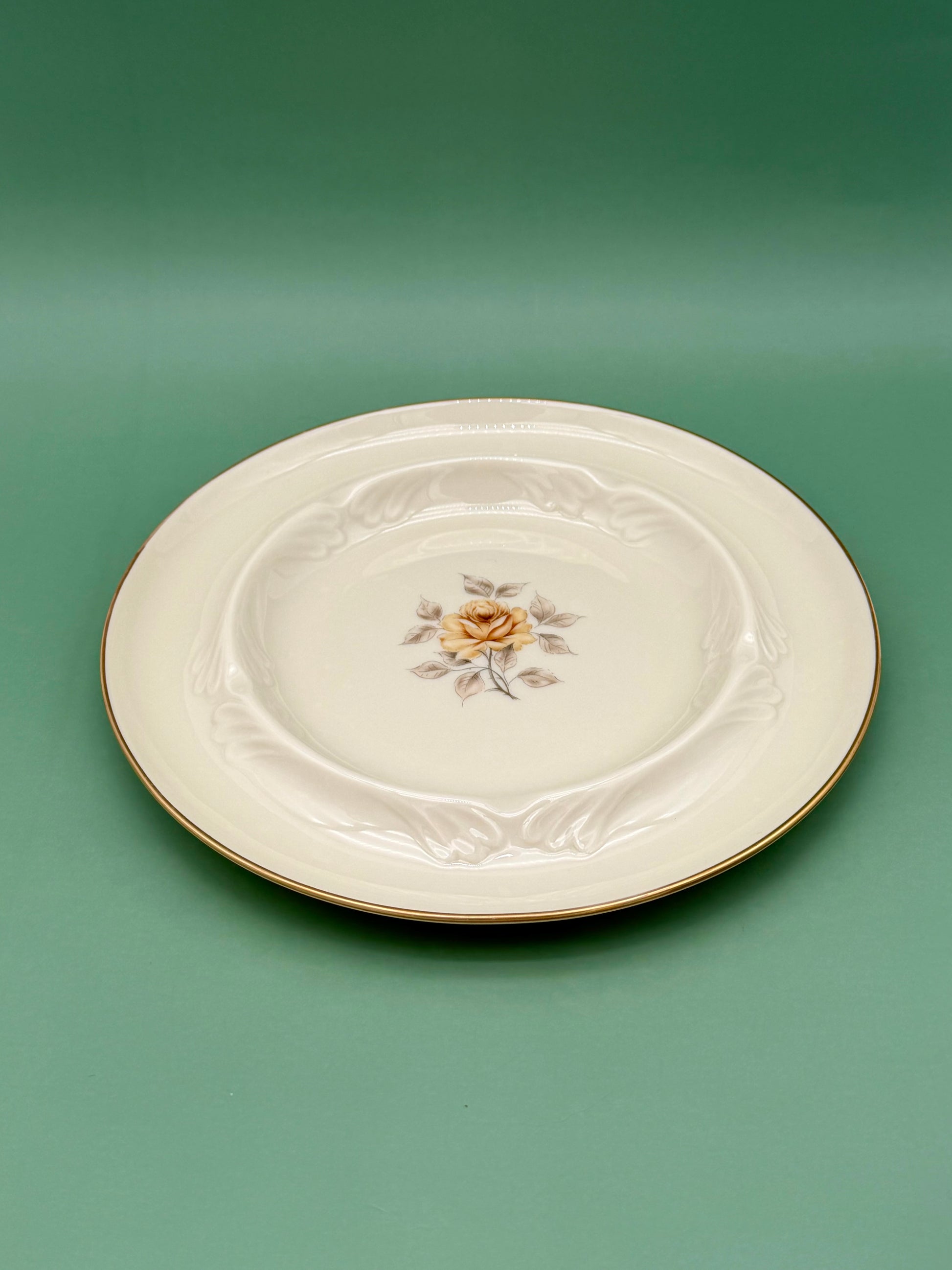 Same oval cream ashtray with the pink rose medallion and gold trim, shown from a different angle, green background.