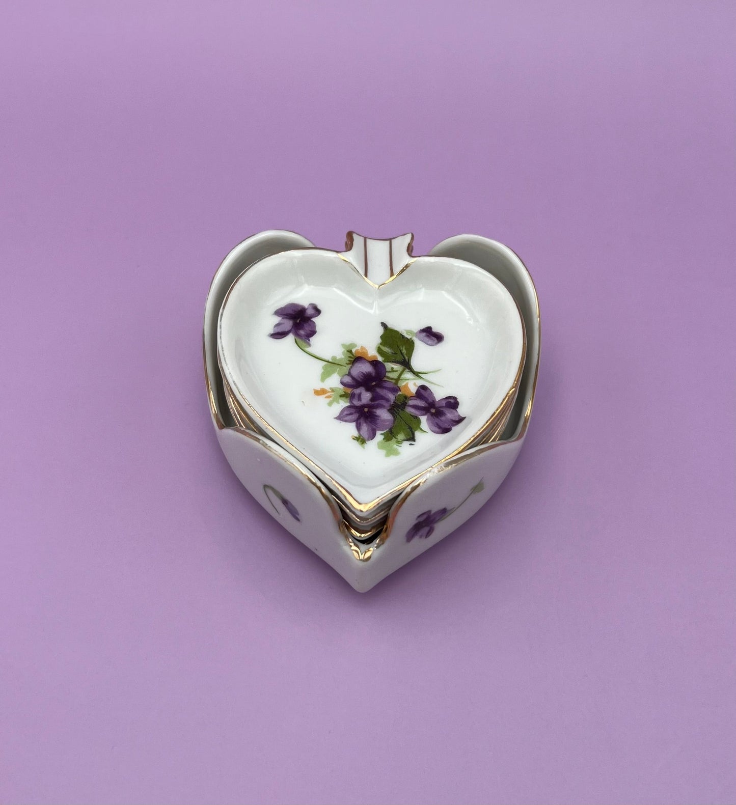 Single heart-shaped porcelain ashtray painted with violets, purple background
