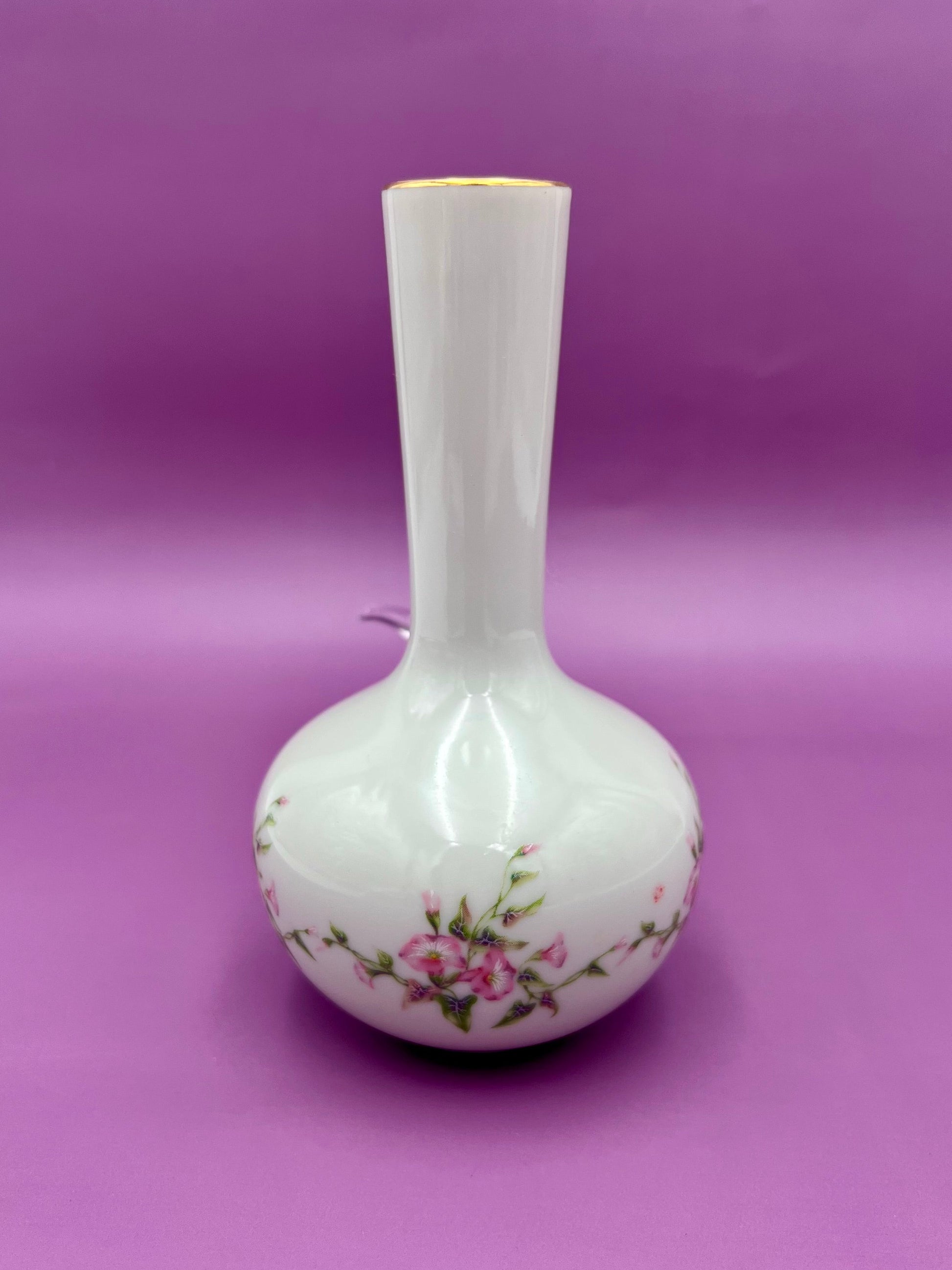 Same white bud vase shown without the bowl piece, highlighting the pink floral design and gold rim trim, purple background.