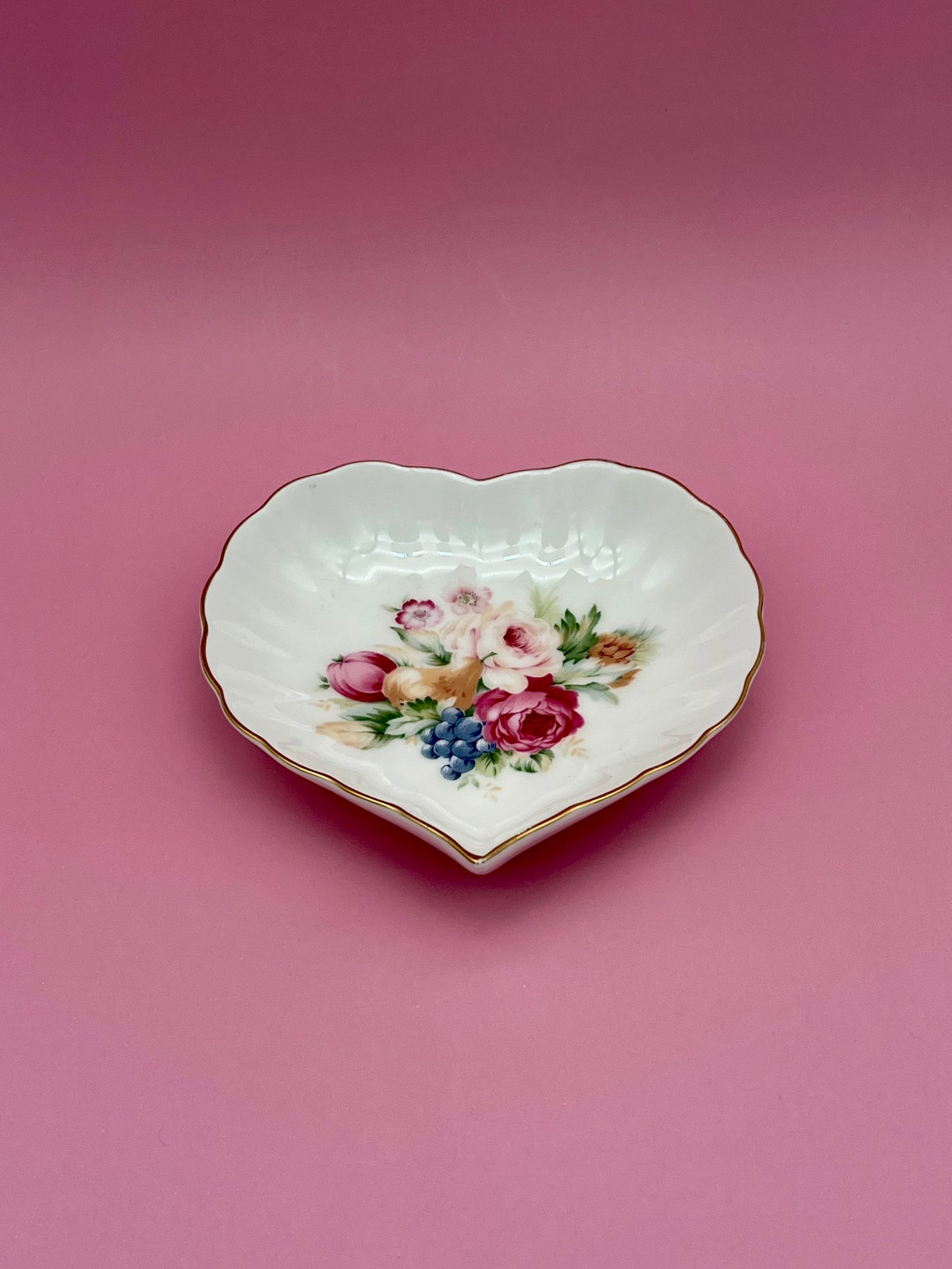 Same heart-shaped floral dish shown without the cigarette pick, closer view, pink background.