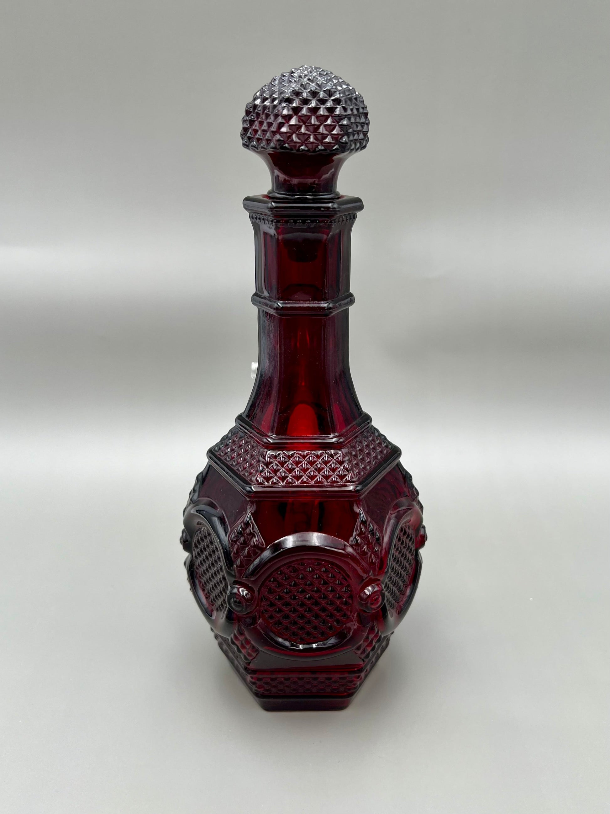 Same ruby red diamond-cut decanter water pipe viewed from a different angle showing the geometric panel cuts on the body, gray background