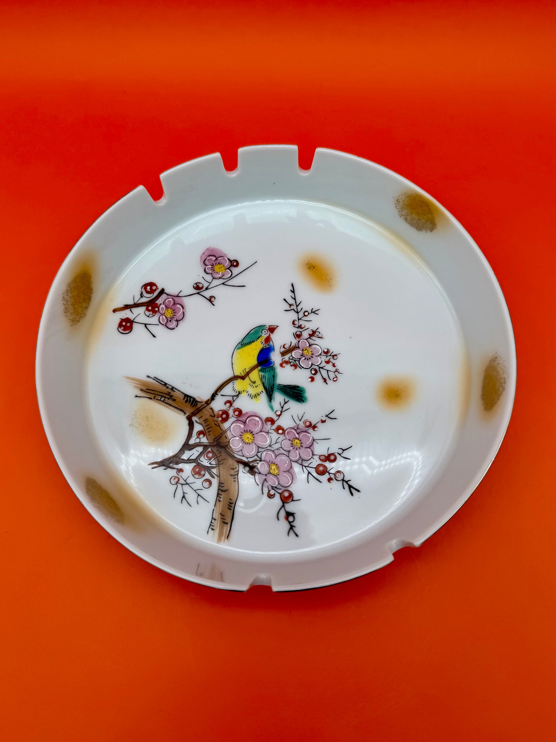 Round cream ashtray from the Verna Set hand-painted with cherry blossoms and a small bluebird, orange background.