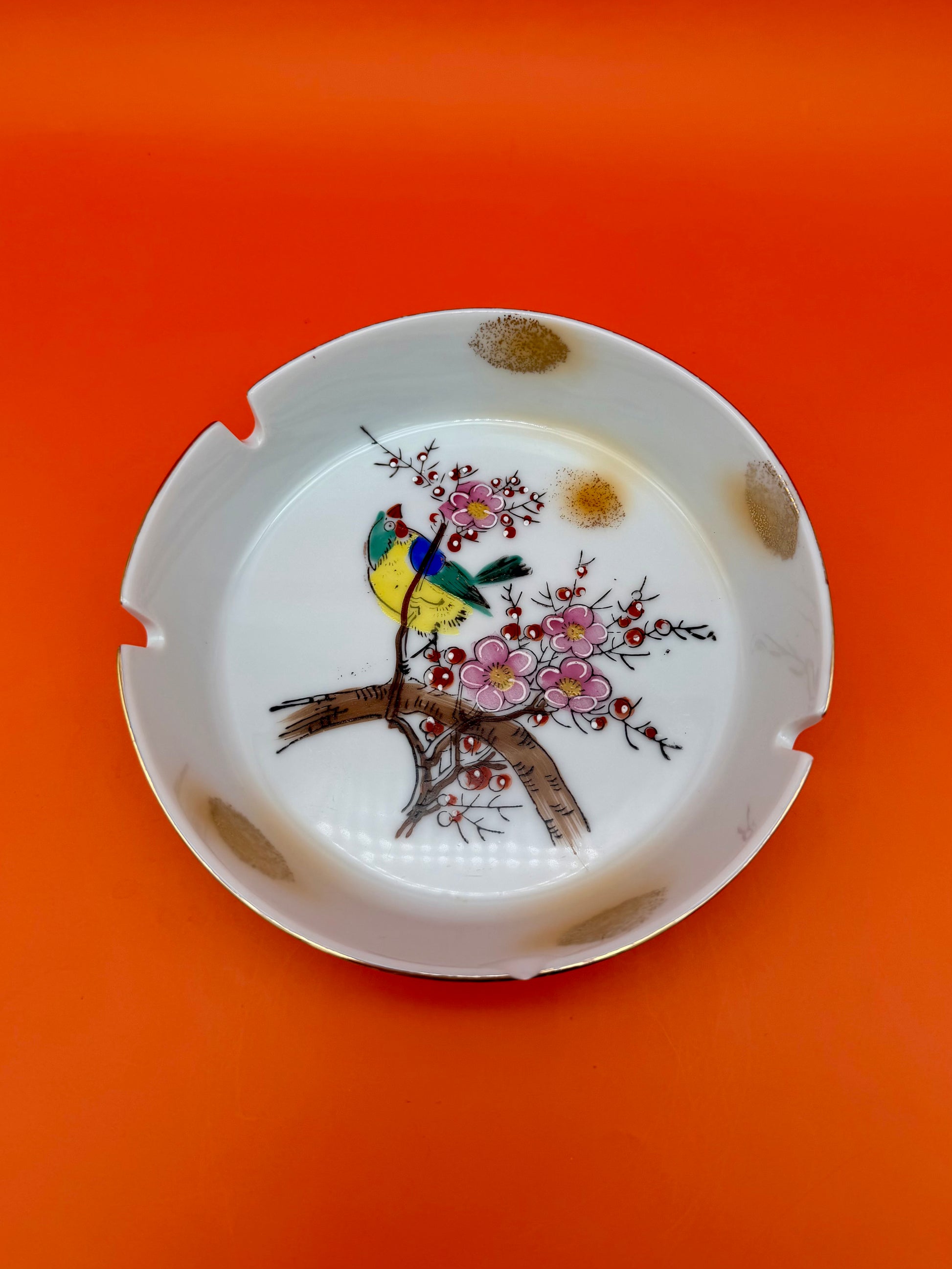 Same round cherry blossom ashtray from the Verna Set shown from a slightly different angle, orange background.