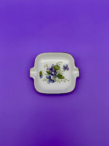 Square white ashtray with gold handles, hand-painted with purple violets, purple background.
